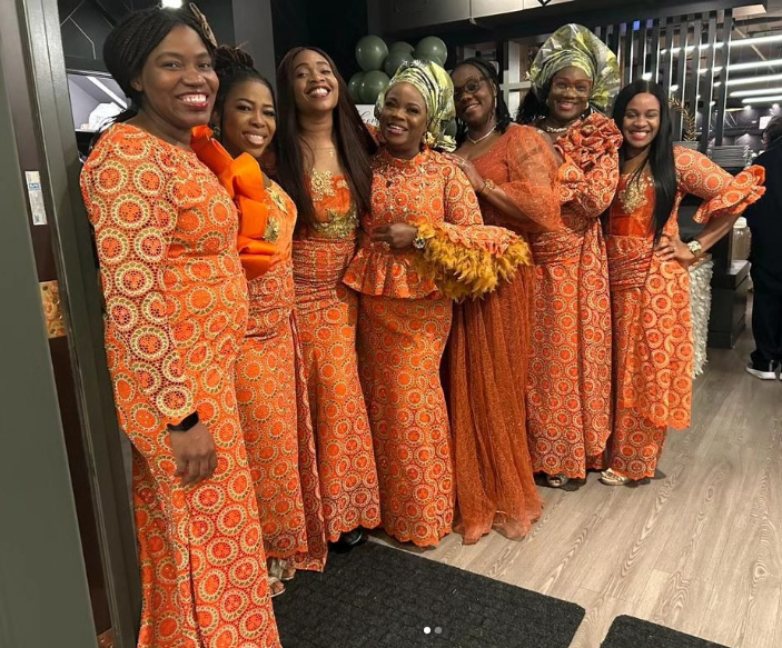 Group of women in matching orange aso-ebi lace outfits sewn by Jovibest Fashions
